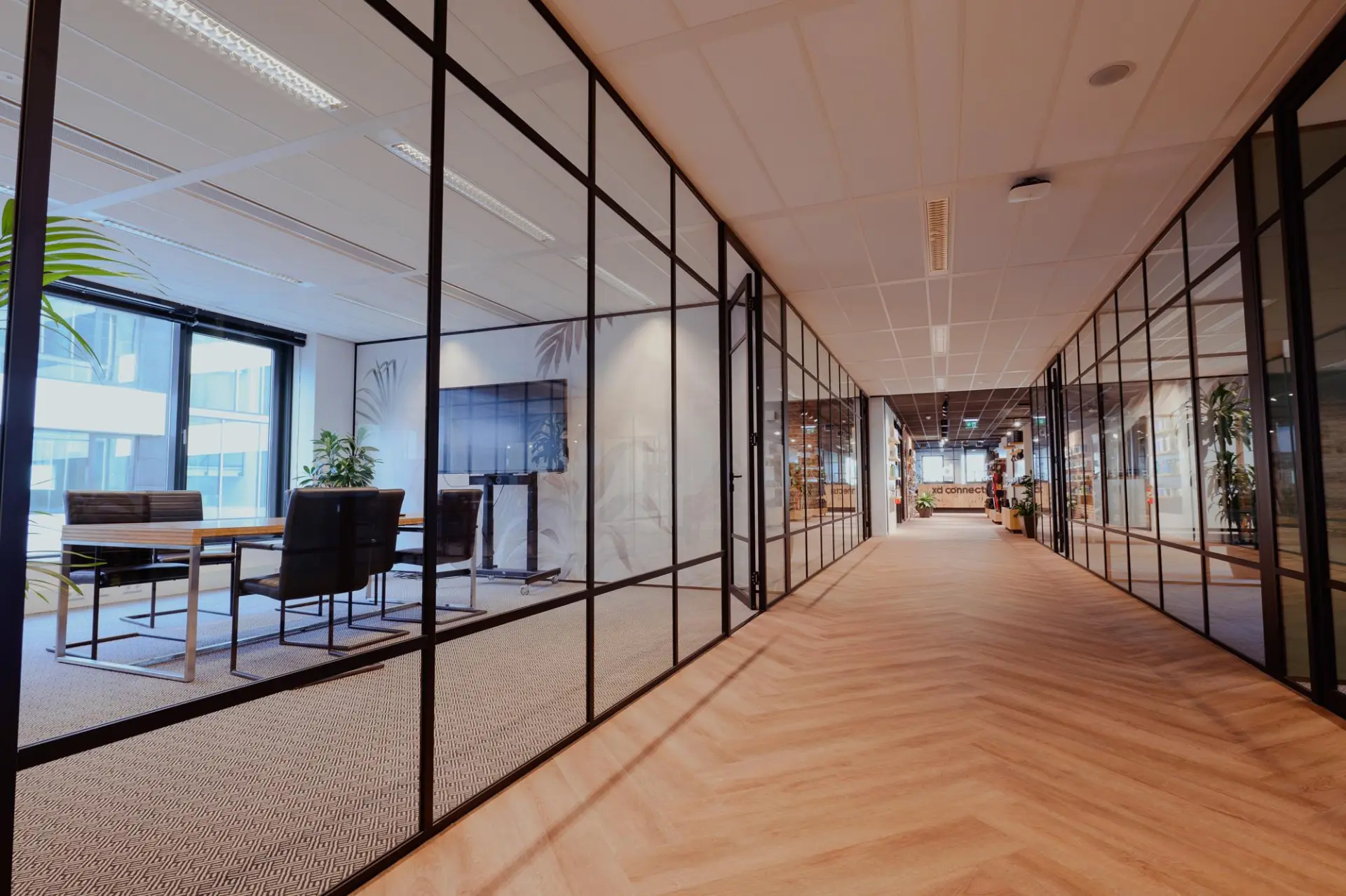 A contemporary advisory office with black-framed glass partitions, meeting rooms and a timber-floored corridor in central perspective