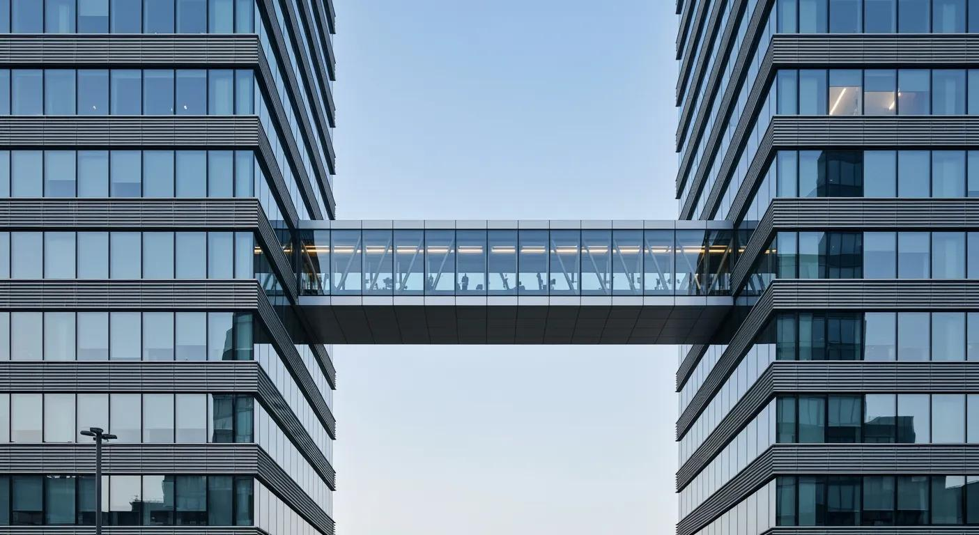 A glazed bridge linking two contemporary buildings across open sky